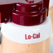 A Tablecraft white plastic salad dressing dispenser collar with maroon lettering on a bottle of l-cal.