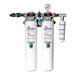 A 3M High Flow water filtration system with two white cylinders and blue labels.