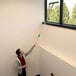 A man using an Unger OptiLoc telescopic pole to clean a window.