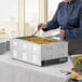 A woman in a chef's uniform uses a ladle to serve food from a Galaxy countertop food warmer.