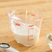 An OXO clear measuring cup with a white liquid in it.