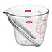 An OXO clear angled measuring cup with red measurements.