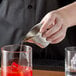 a person pouring liquid into a measuring cup