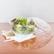 A salad in a Dart clear plastic bowl.