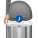 A person holding a blue and white box of simplehuman custom fit trash can liners with a white circle and J in the middle.