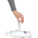 A person's hand holding a white simplehuman trash can liner.