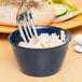 A fork in a Carlisle Dallas Ware cafe blue bouillon cup with white liquid.