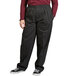 A person wearing Uncommon Chef red and white pinstripe pants with black pants and a maroon shirt.