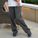 The legs of a person wearing Uncommon Chef customizable yarn-dyed chef pants.
