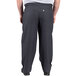 A man wearing Uncommon Chef black and gray houndstooth chef pants with a pocket.