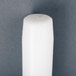 A 12 pack of white Will & Baumer taper candles on a gray surface.