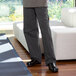 A man wearing Uncommon Chef triple pinstripe chef pants and shoes.