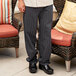 A person wearing Uncommon Chef black and white tribal stripe pants and shoes.