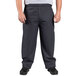 A man wearing Uncommon Chef black and gray houndstooth chef pants and shoes.
