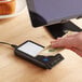 a hand holding money and a device