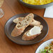 A piece of bread on an Acopa Embers hickory brown stoneware plate.