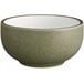 A close up of a moss green Acopa stoneware bowl with a speckled surface.