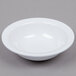 A white Carlisle melamine fruit bowl on a gray surface.