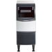 A grey and white Scotsman undercounter ice machine with a black and white base.