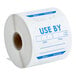 A roll of white paper labels that say "Use By" in blue text.