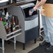 A man standing next to a Scotsman undercounter nugget ice machine on a counter.