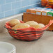 A black wire basket filled with rolls on a counter.