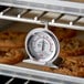 A Cooper-Atkins oven thermometer on a rack of cookies.