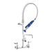 A silver Waterloo low profile wall-mounted pre-rinse faucet with blue handles and a hose.