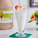 A glass of milkshake with strawberries and bananas made with I. Rice Banana Milkshake Base syrup.