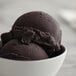 A bowl of black raspberry Italian ice on a white background.