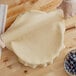 A person holding a ball of pie crust dough.