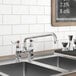 A Waterloo deck-mounted faucet with 4" centers and 12" swing spout on a counter above a sink with a chalkboard on the wall.