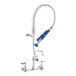 A silver Waterloo low profile wall-mounted pre-rinse faucet with blue handles.