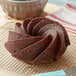 A chocolate bundt cake on a cooling rack.