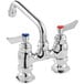 a silver faucet with red knobs