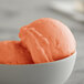 A bowl of orange I. Rice bubble gum water ice on a white background.