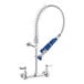 A silver Waterloo low profile wall-mounted pre-rinse faucet with blue handles and a metal tube.