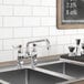 A Waterloo deck-mounted faucet on a counter above a kitchen sink with a blackboard on the wall.