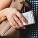 A woman's hand holding a TOPS narrow rule memo book.