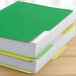 A stack of green and yellow Pendaflex file folders.