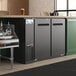 An Avantco back bar refrigerator on a counter with a galvanized top.