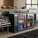 An Avantco UBB-60-GT-G back bar refrigerator with drinks and bottles inside.
