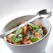 A bowl of food with a spoon on a table with a Front of the House Harmony bright white porcelain cup.