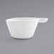A white porcelain cup with a spoon in it.