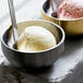 Two Front of the House stainless steel double wall bowls filled with ice cream on a table.