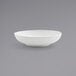 A Front of the House Harmony bright white low round porcelain bowl on a gray surface.