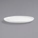 A white Front of the House Harmony oval porcelain plate on a gray surface.