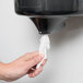 A person's hand using a Lavex Junior white center pull paper towel