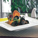 A table set with a Front of the House bright white square bowl filled with seafood.