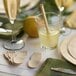 A table setting with a glass of liquid and Bambu wooden sporks.